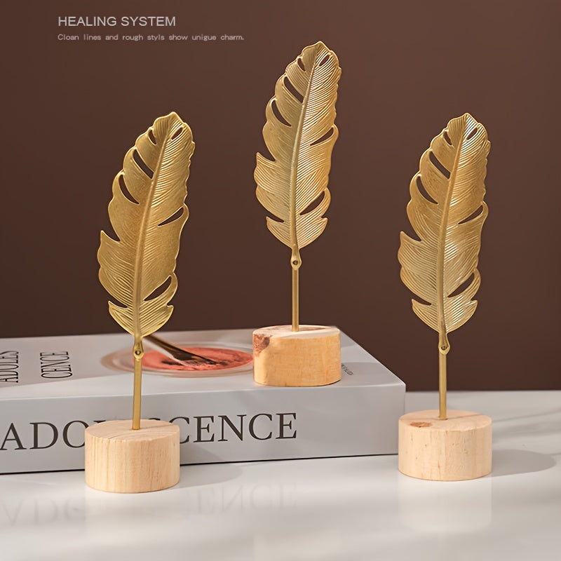 Skulptur med bladmotiv i metal på træfod til indendørs brug