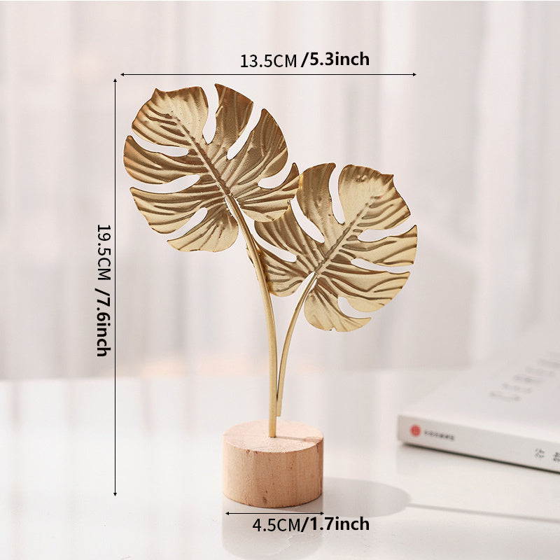 Sculpture with leaf motif in metal on wooden base for indoor use