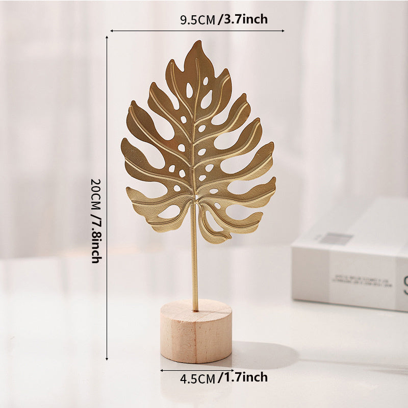 Sculpture with leaf motif in metal on wooden base for indoor use