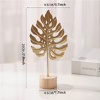 Sculpture with leaf motif in metal on wooden base for indoor use
