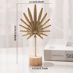 Sculpture with leaf motif in metal on wooden base for indoor use
