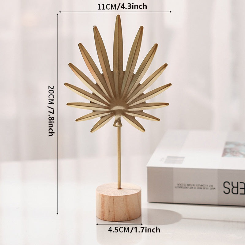 Skulptur med bladmotiv i metal på træfod til indendørs brug