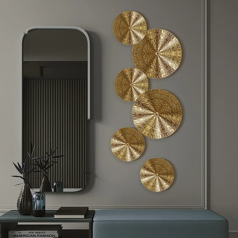 Cirkelformet vægdekoration i metal med guldfinish